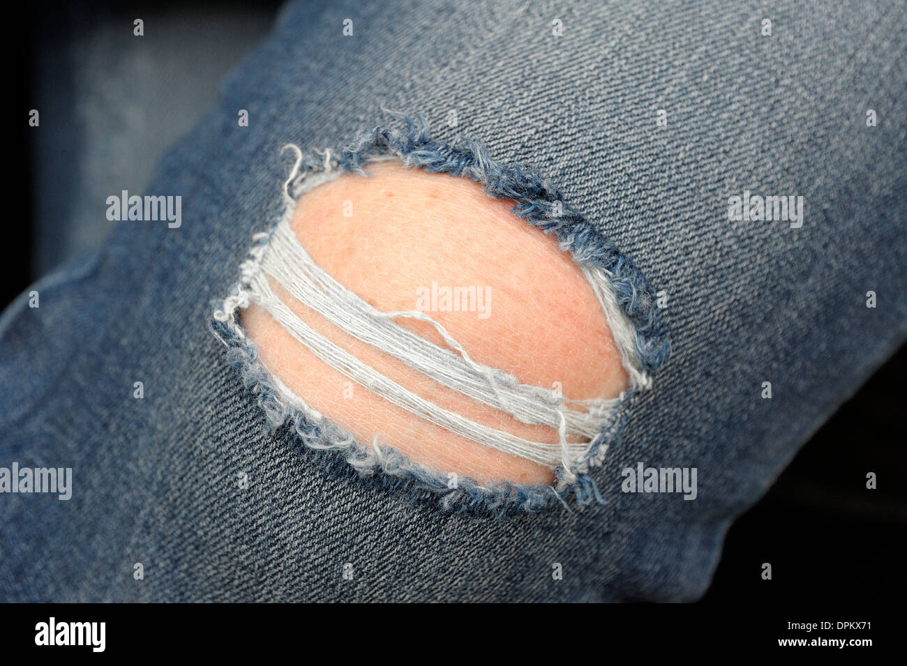 Denim-Jeans getragen wird, mit einem großen Loch im Knie Stockfotografie -  Alamy
