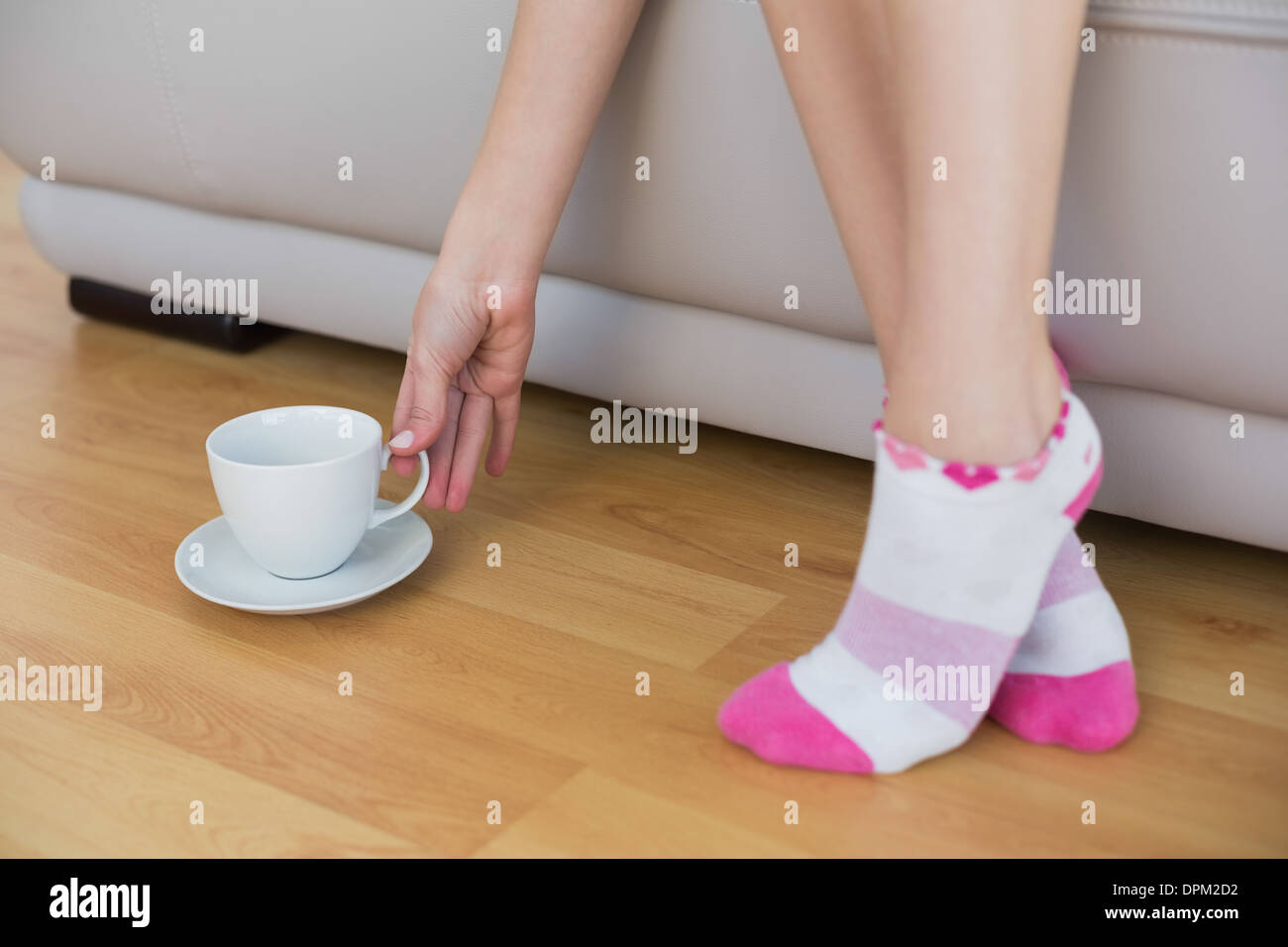 Schlanke Frau Rosa Socken erreichen für eine Tasse Stockfoto