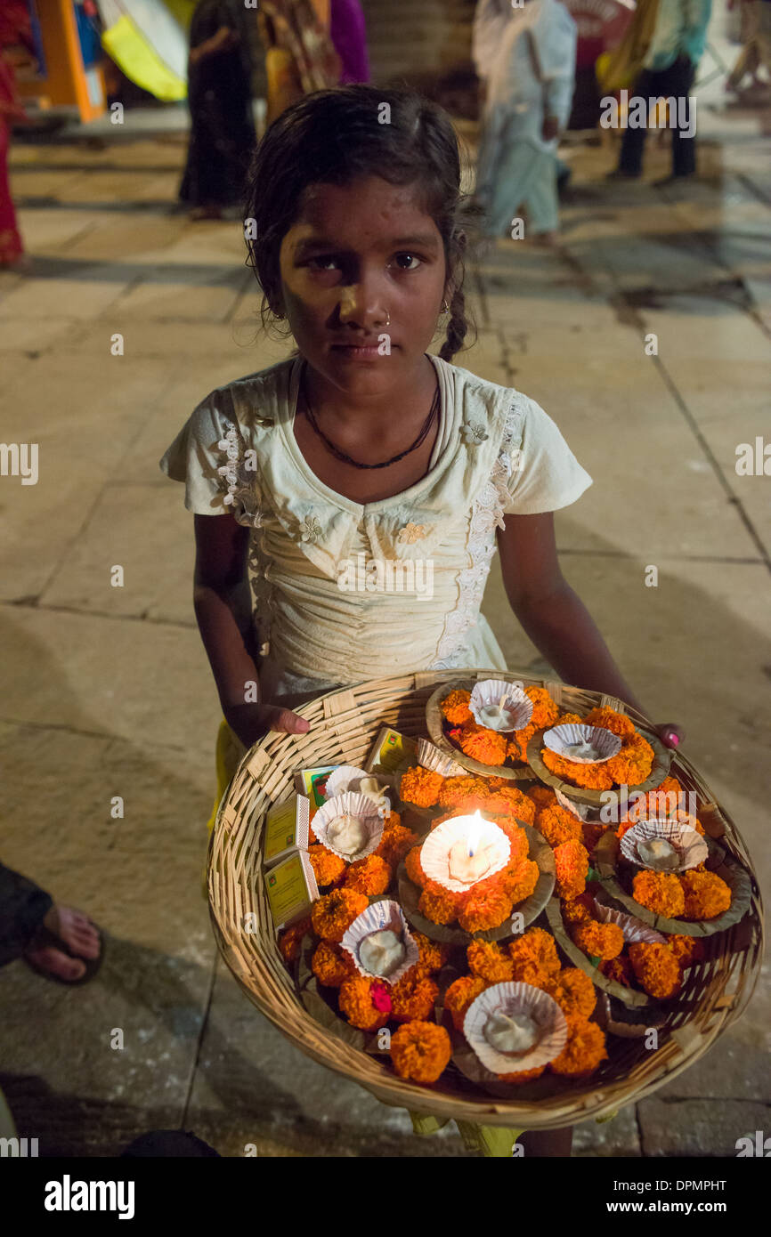 Junges Mädchen verkaufen Angebote werden schwebte hinunter den Fluß Ganges nach dem Ganga Aarti Zeremonie und Feuer Puja, Dashashwamedh Ghat, Varnasi, Uttar Pradesh, Indien Stockfoto