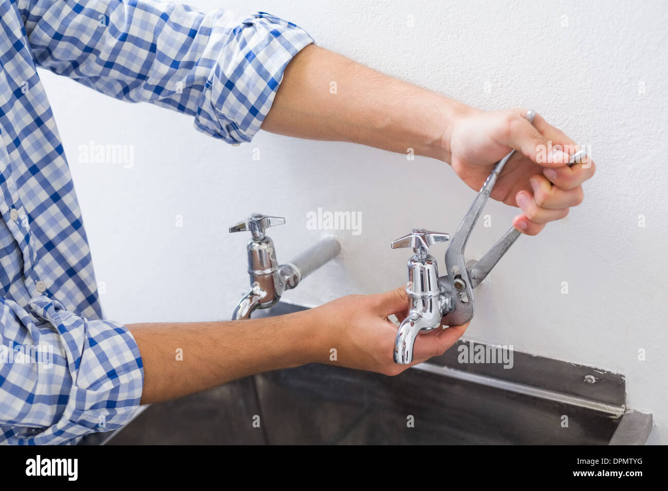 Klempner Hand Befestigung Wasserhahn mit einer Zange Stockfoto