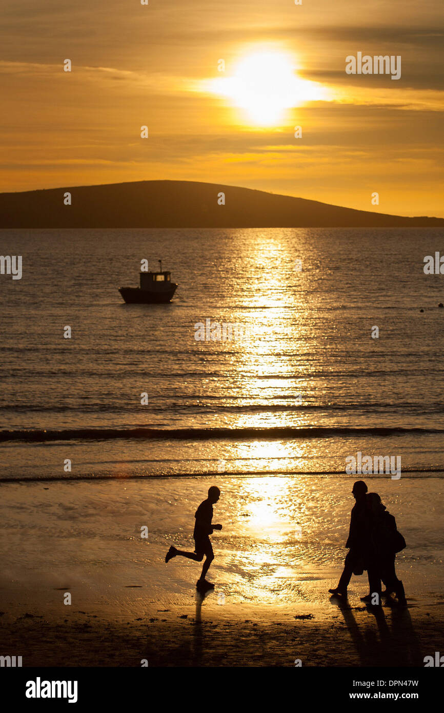 Leute laufen entlang des Strandes in Weston-Super-Mare Stockfoto