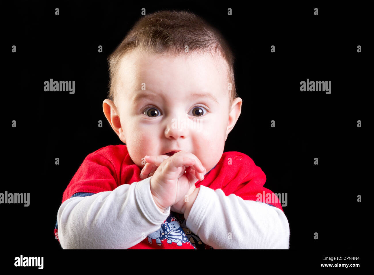Baby Boy auf schwarzem Hintergrund Stockfoto