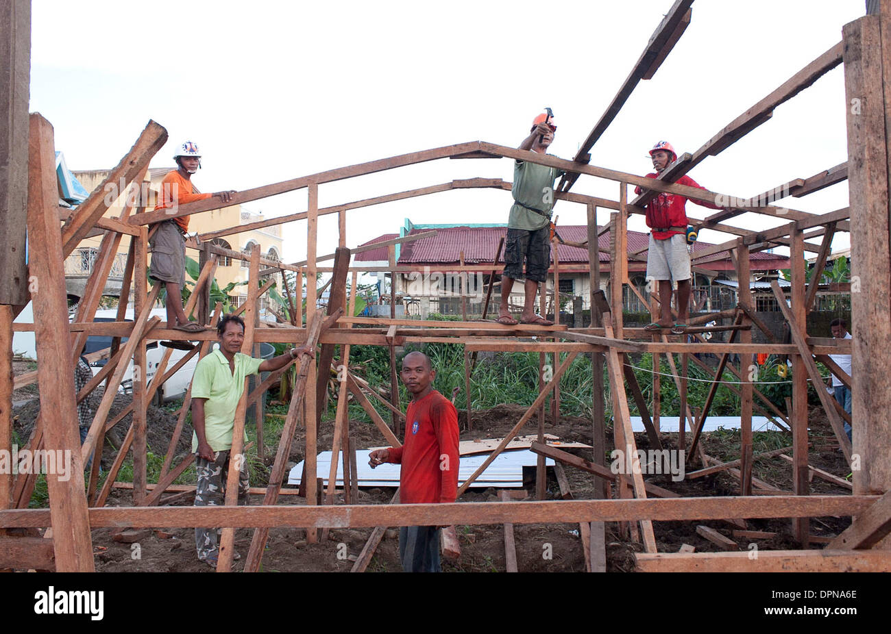 Tacloban, Deutschland. 15. Dezember 2013. Männer bauen ein Holzhaus in Tacloban, Deutschland, 15. Dezember 2013. Gute zwei Monate nach dem Taifun "Haiyan" durch die Philippinen, Riss versuchen die Überlebenden, ihr Leben und ihre Häuser wieder aufzubauen. Foto: JOHN GRAFILO/Dpa/Alamy Live News Stockfoto