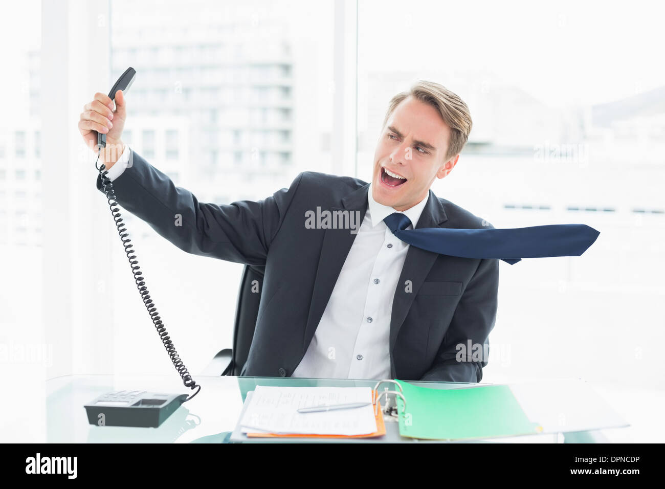 Geschäftsmann, schreien, als er hält, Telefon im Büro Stockfoto