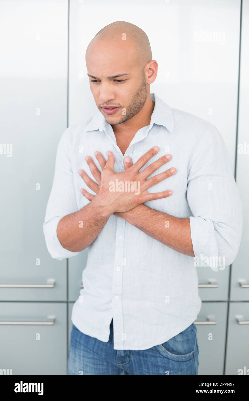 Lässige jungen Mann mit Schmerzen in der Brust zu Hause Stockfoto