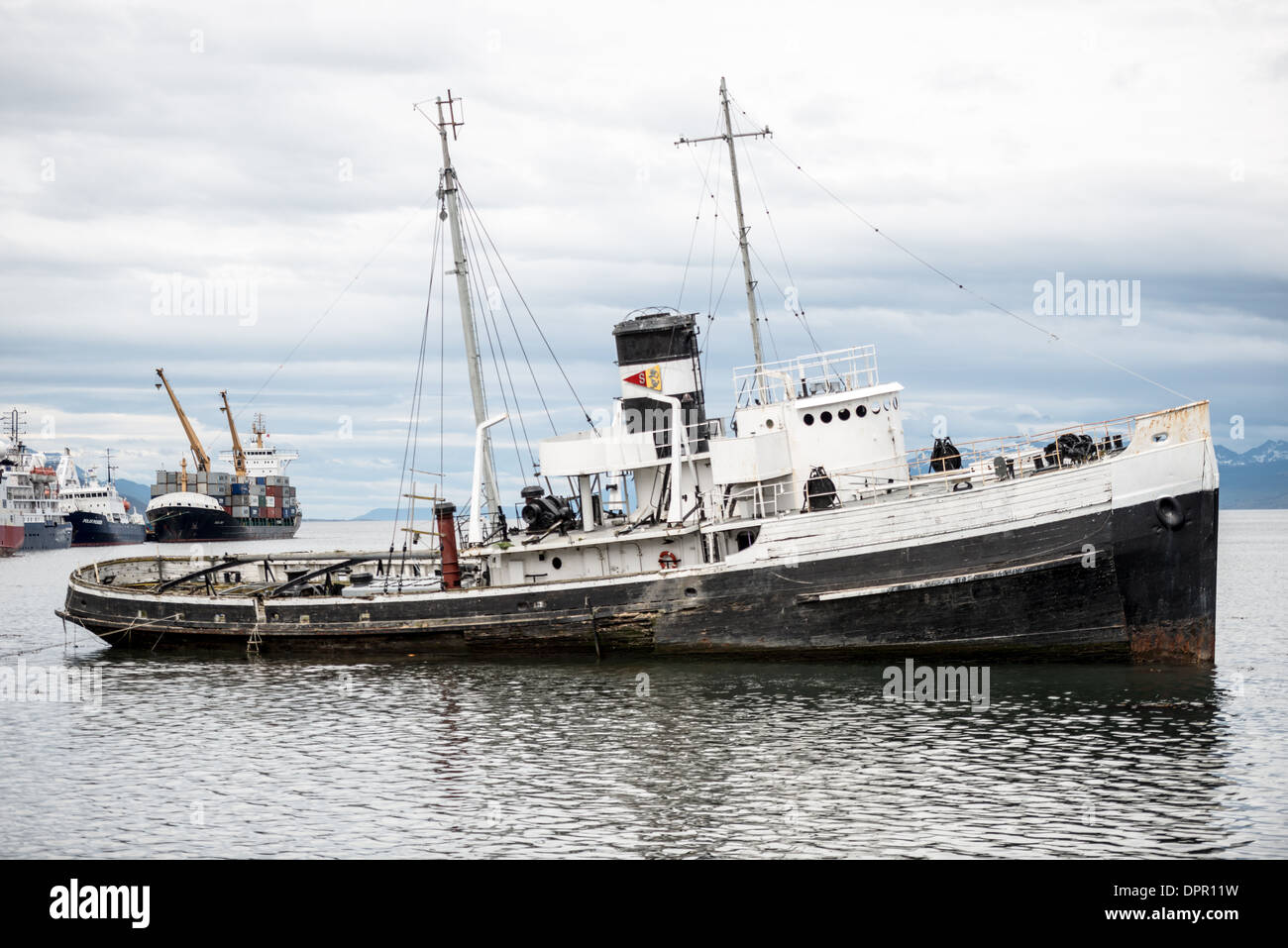USHUAIA, Argentinien - das Wrack des Heiligen Christopher (HMS Justice) auf Grund im Hafen von Ushuaia, Argentinien. Der Sain Christopher ist ein in den USA gebauter Rettungsschlepper, der im Zweiten Weltkrieg in der britischen Royal Navy diente Nach dem Krieg wurde sie im Royal Nay stillgelegt und zur Bergung im Beagle-Kanal verkauft. Nachdem sie 1954 unter Motorenproblemen gelitten hatte, wurde sie 1957 im Hafen von Ushuaia gestrandet, wo sie heute als Denkmal für die Schiffswracks der Region dient. Eingebettet an der Südspitze Südamerikas ist Ushuaia als die südlichste Stadt der Welt bekannt. Mit Blick auf t Stockfoto