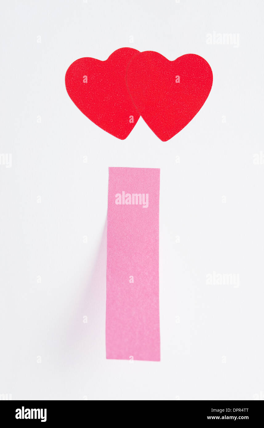 Zwei rote Herzen und einer Notiz auf Papierblatt geklebt Stockfoto