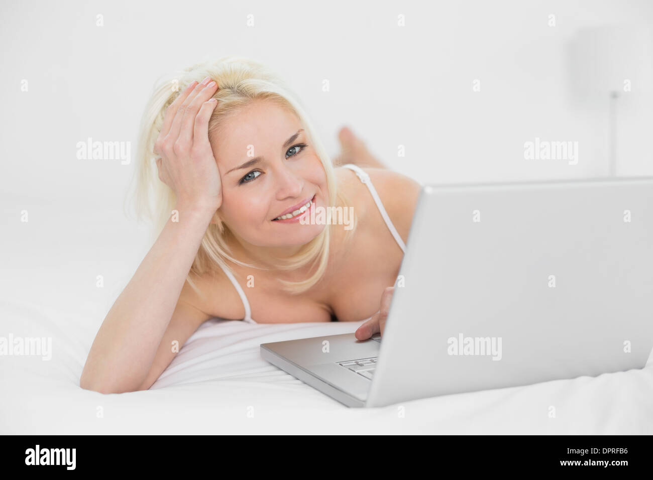 Lässig entspannte Blond mit Laptop im Bett Stockfoto