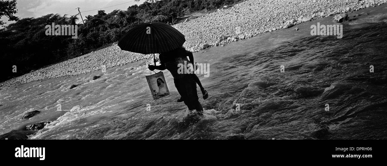 28. November 2008 - Haiti - eine Mutter und Tochter überqueren einen Fluss an der Grenze zwischen Haiti und der Dominikanischen Republik-Fluss nach dem Einkauf in einem anderen Dorf. Die Leben der Armen in den Tropen werden durch Geographie und Wetter, Dürre und Sturzflut, drückende Hitze und drückende Armut geregelt. Die Landschaft, der Touristen als idyllisches Paradies in saubere, sichere Orte kann nur denken kann Stockfoto
