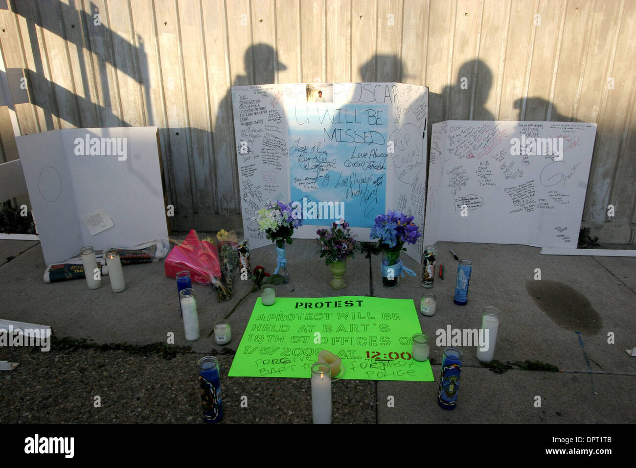 Die Schatten der Friends of Oscar Grant, betrachten ein Denkmal zu seinen Ehren auf den Fruitvale BART-Station in Oakland, Kalifornien. auf Sonntag, 4. Januar 2009. Grant wurde erschossen und von BART Polizei kurz nach der Haft nach einem Aufruhr in einem Zug getötet. (Jim Stevens/Personal) Stockfoto