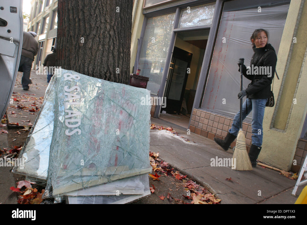 Gereltsetseg Batsaikhan fegt das Glas eine defekte Frontscheibe des neuen reinen natürlichen Cafe Donnerstag, 8. Januar 2009.  Sie ist der Manager und sollte am Montag geöffnet. Einem heftigen Protest über die Erschießung des Oscar Grant von einem BART Polizeibeamten fegte durch die Innenstadt von Oakland Mittwochabend beschädigen viele Geschäfte entlang 17. Straße und rund um die Innenstadt Stockfoto