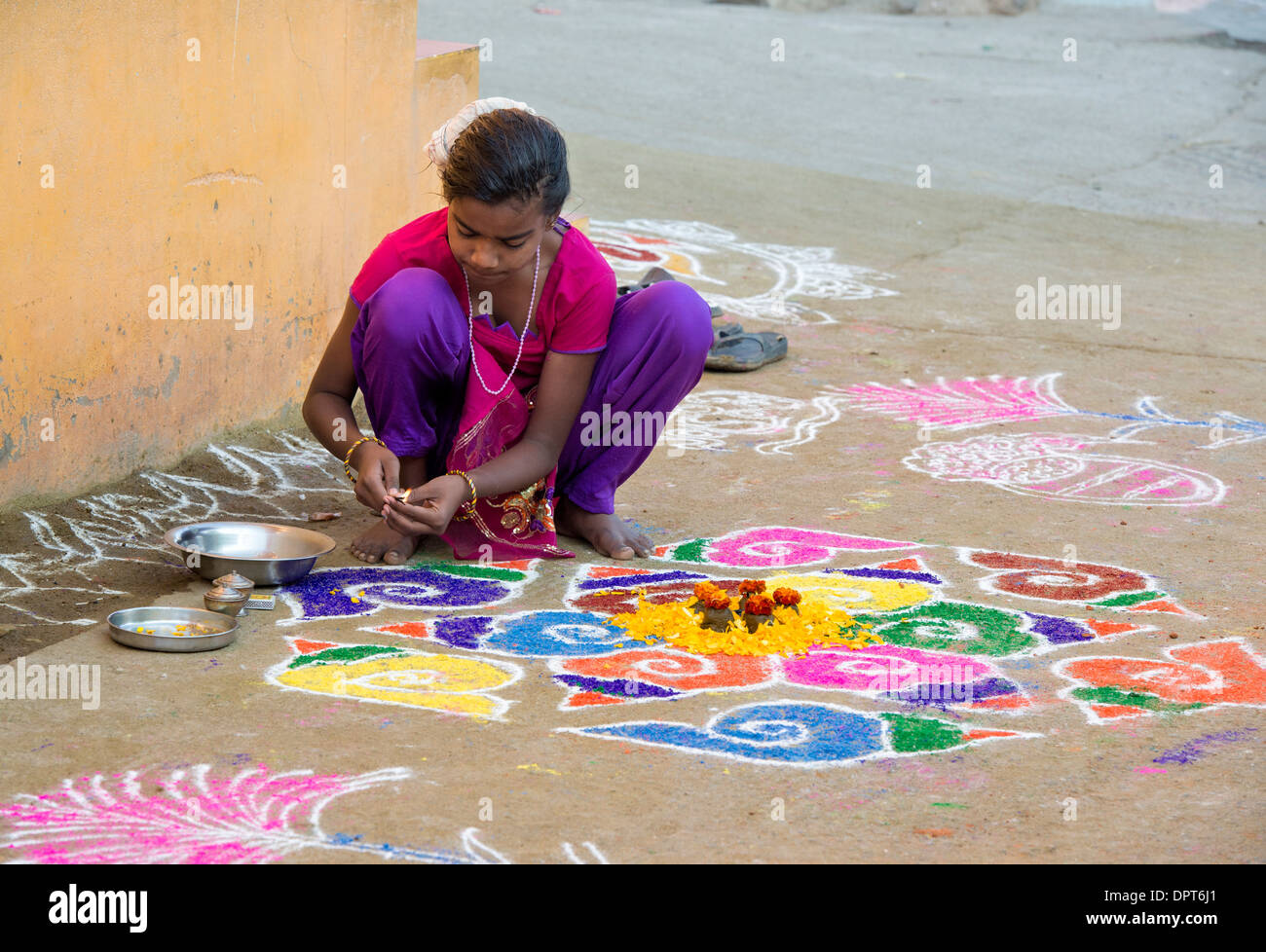 Indisches Mädchen machen Rangoli Festival farbigen Pulver Designs Sankranti in einem indischen Dorf. Andhra Pradesh, Indien Stockfoto