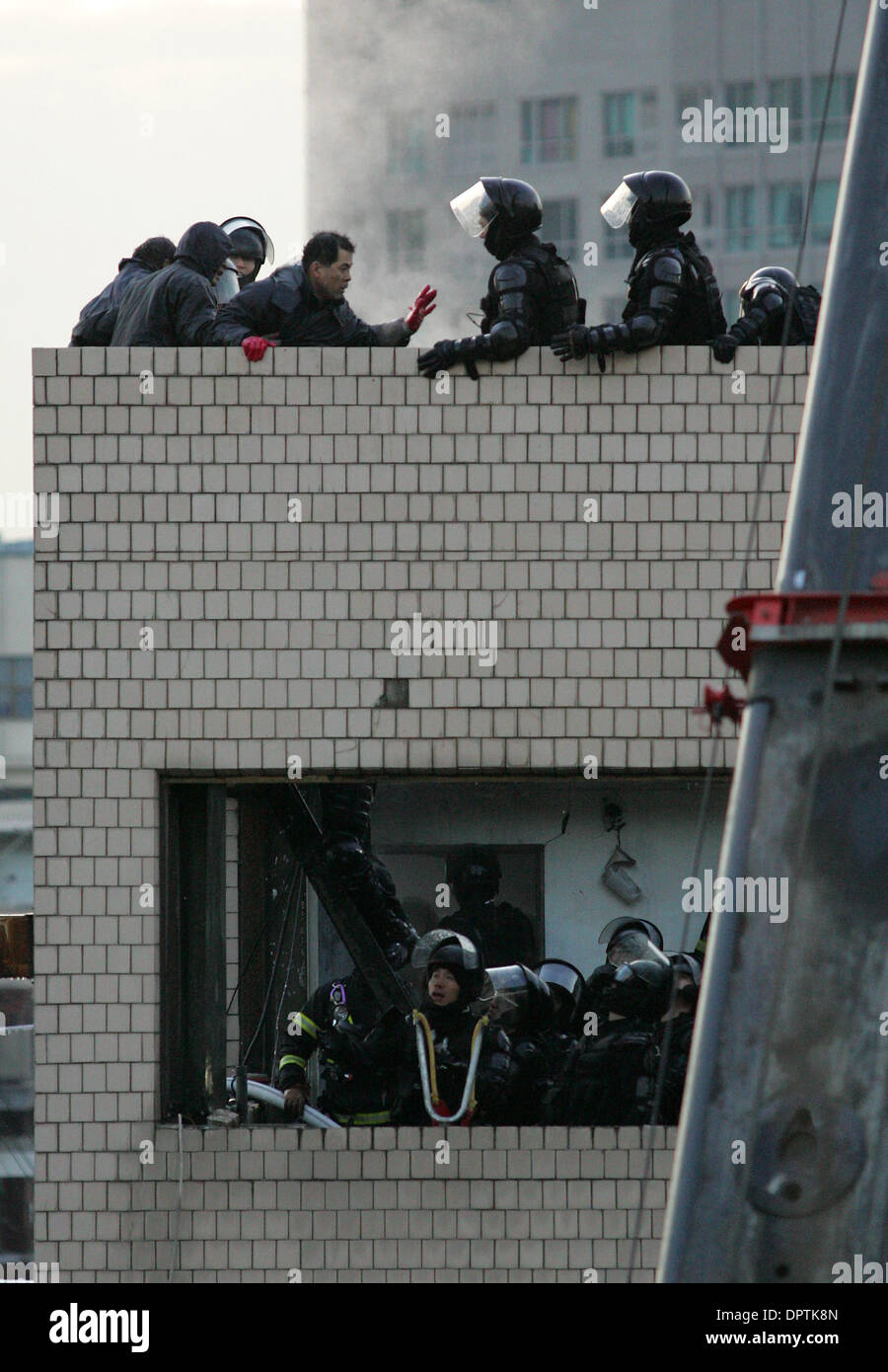 20. Januar 2009 Sturm - Seoul, Südkorea - Polizei ein Gebäude durch Hausbesetzer in zentralen Seoul am Dienstag, Funkenbildung eine Auseinandersetzung und eine Blesse, die mindestens 4 Personen und links 17 verletzt getötet. Kommandos überfallen der vierstöckigen Gebäude zu einem Streik von rund 40 geführt brechen Menschen lagerten in einem Sanierungsplan zu protestieren. Bild: südkoreanische Polizei Nähe auf die Hausbesetzer auf t Stockfoto