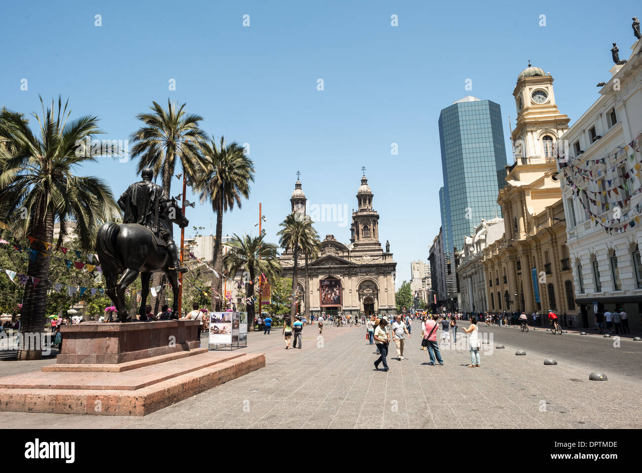Plaza de Armas Pedro de Valdivia Statue Santiago Chile | SANTIAGO, Chile – eine Reiterstatue des Eroberers Pedro de Valdivia steht an der Plaza de Armas, dem Platz, den er nach der Gründung der Stadt 1541 als Gründungszentrum von Santiago angelegt hat. Die neoklassizistische Metropolitan Cathedral und der gelbe Königliche Hofpalast ragen dahinter auf und flankieren den platz, der das bürgerliche und religiöse Leben der Stadt seit fast fünf Jahrhunderten verankert hat. Ein gläserner Büroturm hinter ihnen markiert die moderne Skyline von Santiago. Stockfoto