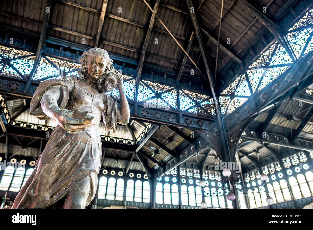 SANTIAGO, Chile - eine Statue einer Frau, die Wasser transportiert, im Zentrum des Mercado Central de Santiago, Chiles zentralem Markt. Der Markt ist auf Meeresfrüchte spezialisiert, eine Grundnahrungsmittel-Kategorie der chilenischen Küche. Das Gebäude ist mit einem kunstvoll verzierten gusseisernen Dach versehen. Dieser Markt aus dem 19. Jahrhundert ist ein Zeugnis der lebendigen kulinarischen Kultur von Santiago und ein bedeutender Ort für Einheimische und Touristen, um authentische chilenische Gastronomie zu erkunden. Stockfoto