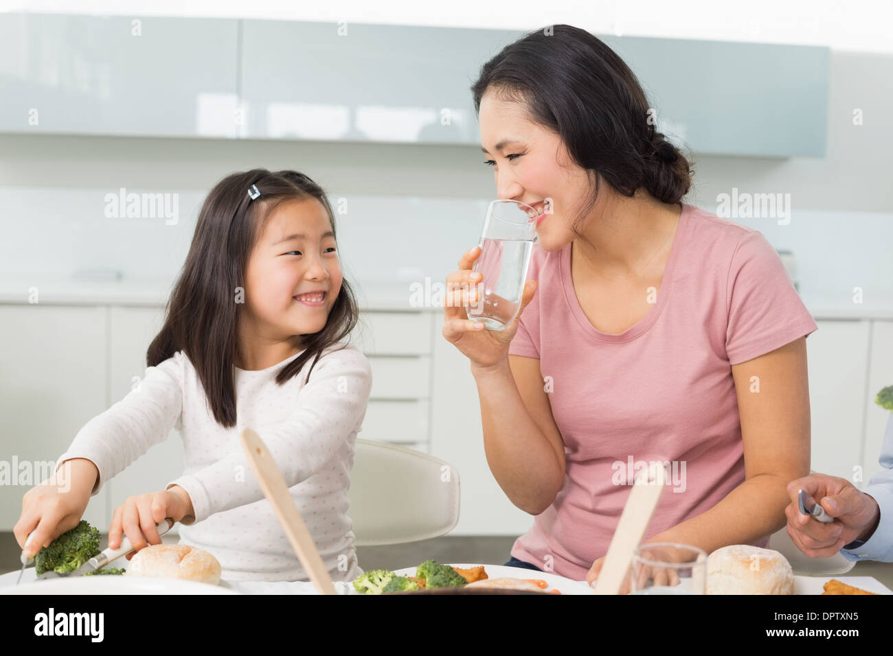 Kleine Mädchen und Mutter Essen in Küche Stockfoto