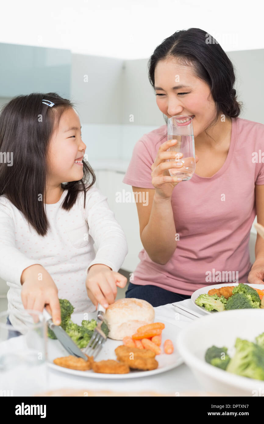 Mutter, die gerade kleine Mädchen Essen in der Küche Stockfoto