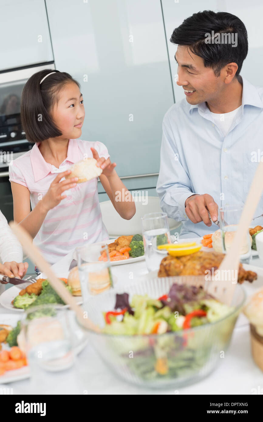 Vater beobachtete kleine Mädchen Essen in der Küche Stockfoto