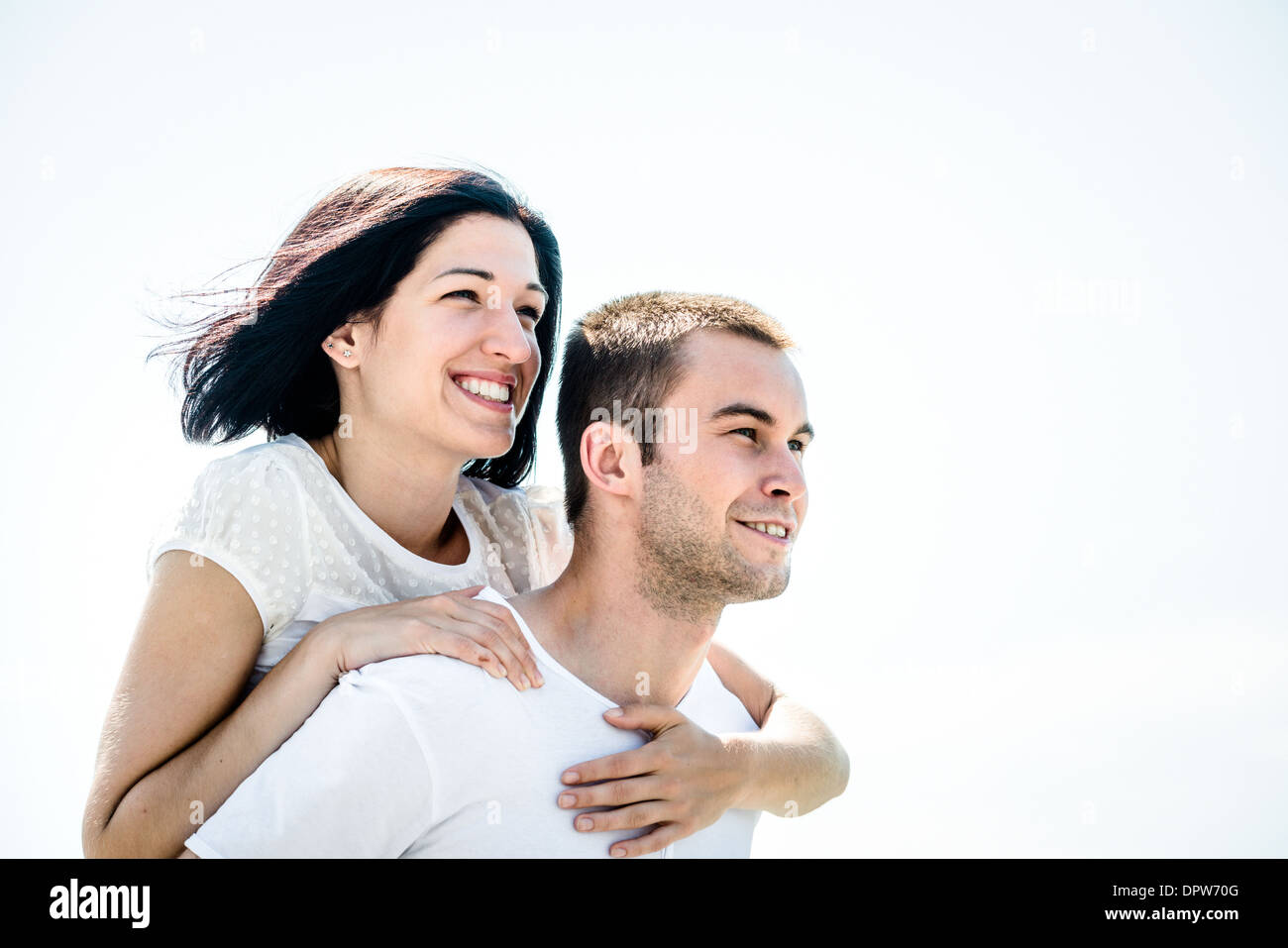 Junges Paar auf helle Zukunft - glückliche Frau umarmt ihre Liebe um Hals Stockfoto