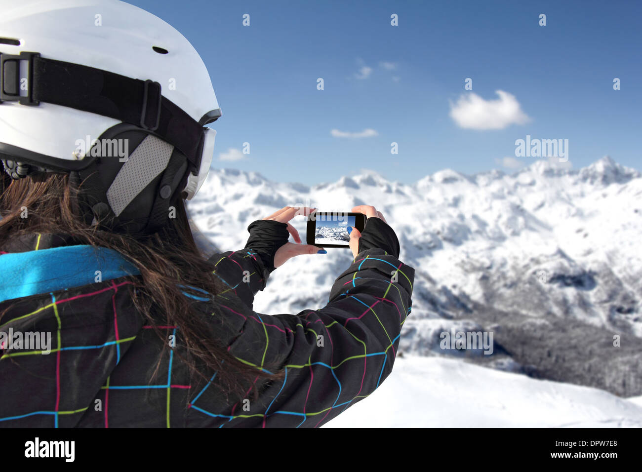 Mädchen, die die Bilder auf einer Handy-Winterlandschaft Berge unter Schnee Stockfoto
