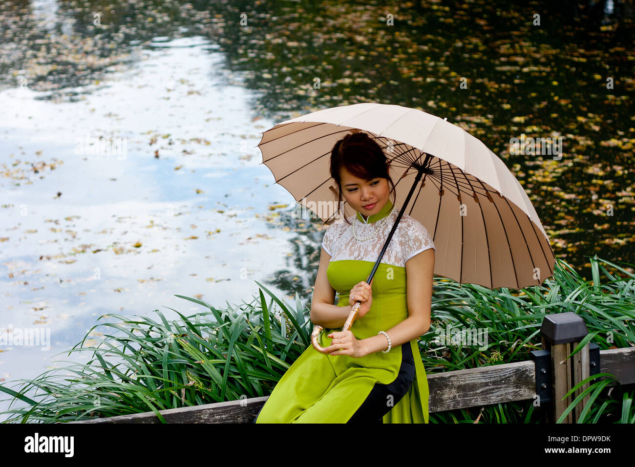 Young Lady Holding-Dach an einem Teich Stockfoto