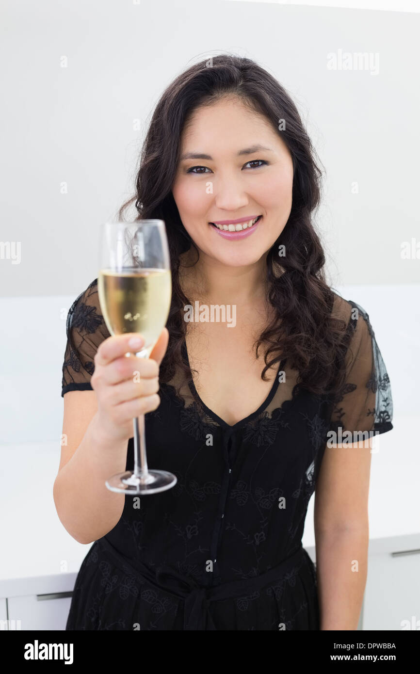 Porträt einer lächelnden jungen Frau mit Champagner Stockfoto