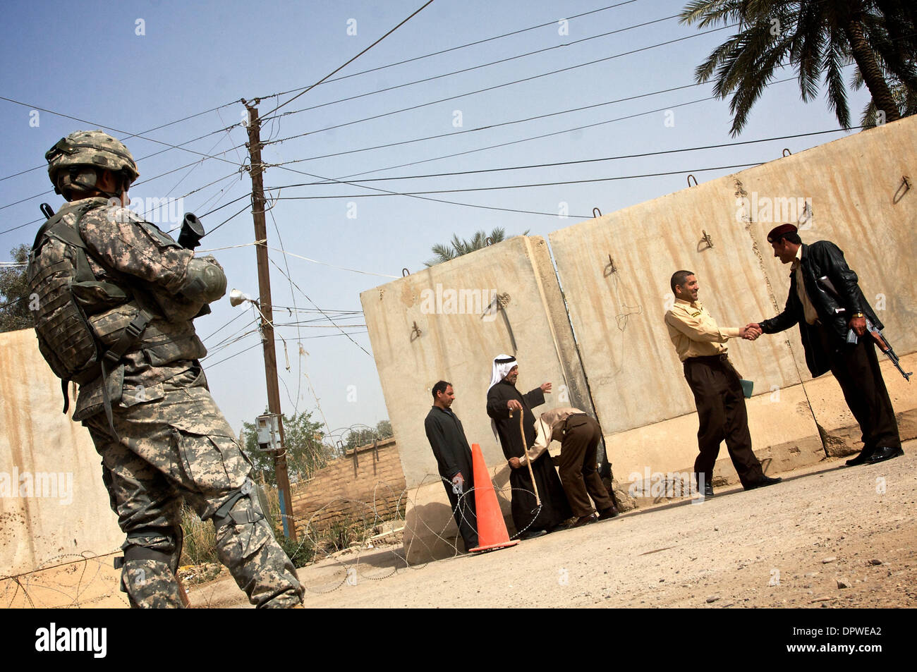 23. März 2009 - Baquba, Irak - irakische Sicherheit Kräfte Suche Gäste in das Büro des Bürgermeisters in Baquba, während eines Soldaten der US Army 125 SBCT, 1/5-Infanterie-Bataillon überwacht, wie Menschen für Waffen und Sprengstoff durchleuchtet werden.  (Kredit-Bild: © John Goodman / ZUMA Press) Stockfoto