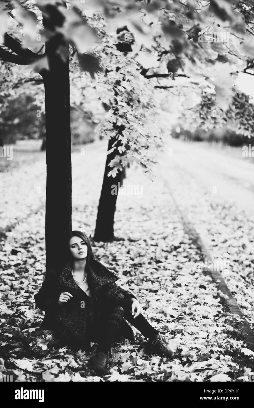 Junge Frau unter Baum. Schwarz / weiß-Film-Stil-Farben. Stockfoto