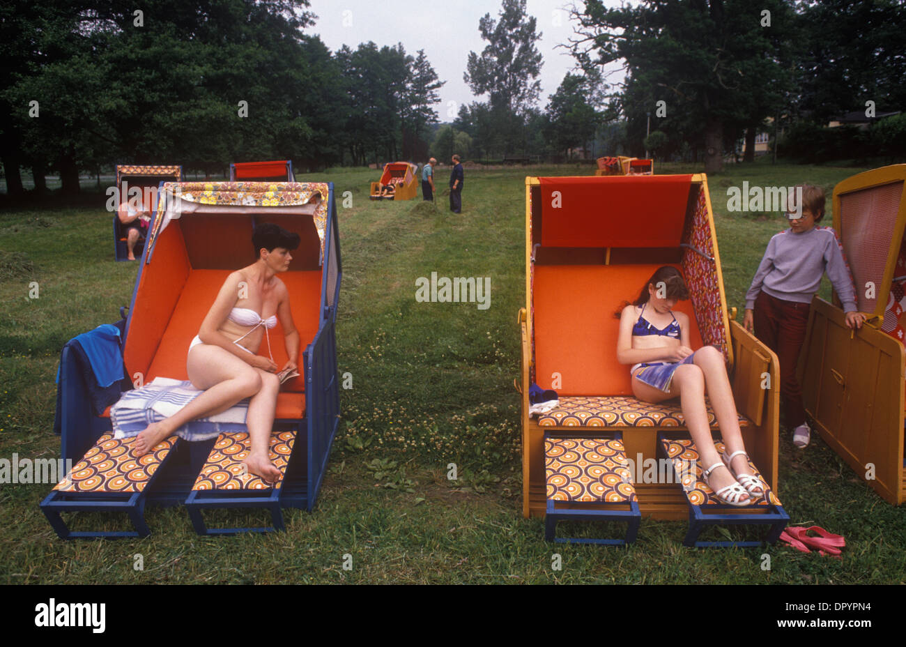 Boitzenburg, Ostdeutschland. Familien der DDR-Armee, die in einem staatlichen Ferienresort, der teilweise von der Regierung HOMER SYKES in den 1990er Jahren BEZAHLT wurde, doppelte Liegestühle benutzten Stockfoto