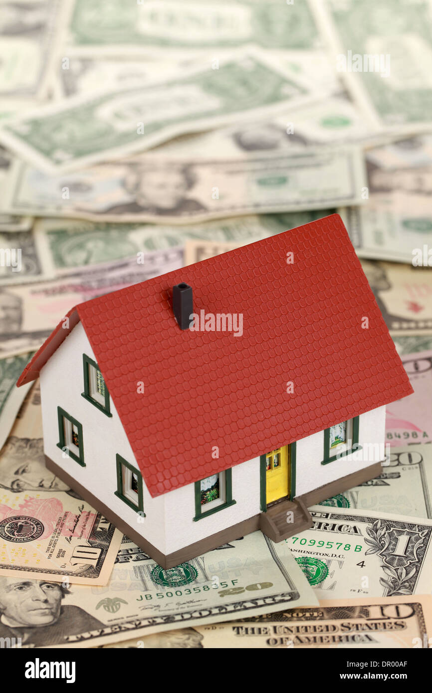 Symbolisches Bild für eine Immobilienfinanzierung mit einem Haus auf Dollarnoten Stockfoto