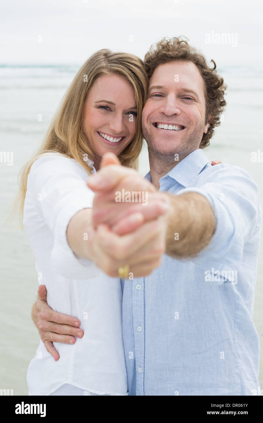 Glückliches junges Paar am Strand tanzen Stockfoto