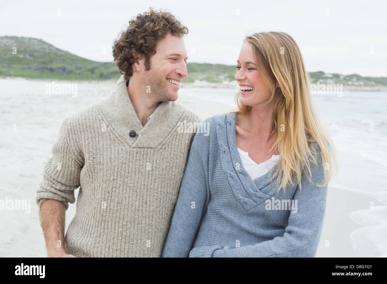 Lässige Hochzeitspaar am Strand lachen Stockfoto