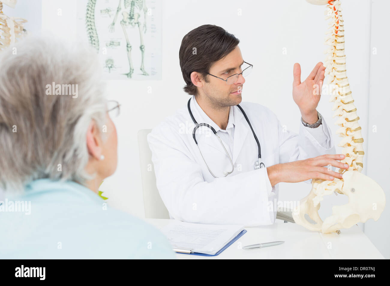 Männlichen Arzt erklären, die Wirbelsäule zu einem älteren Patienten Stockfoto