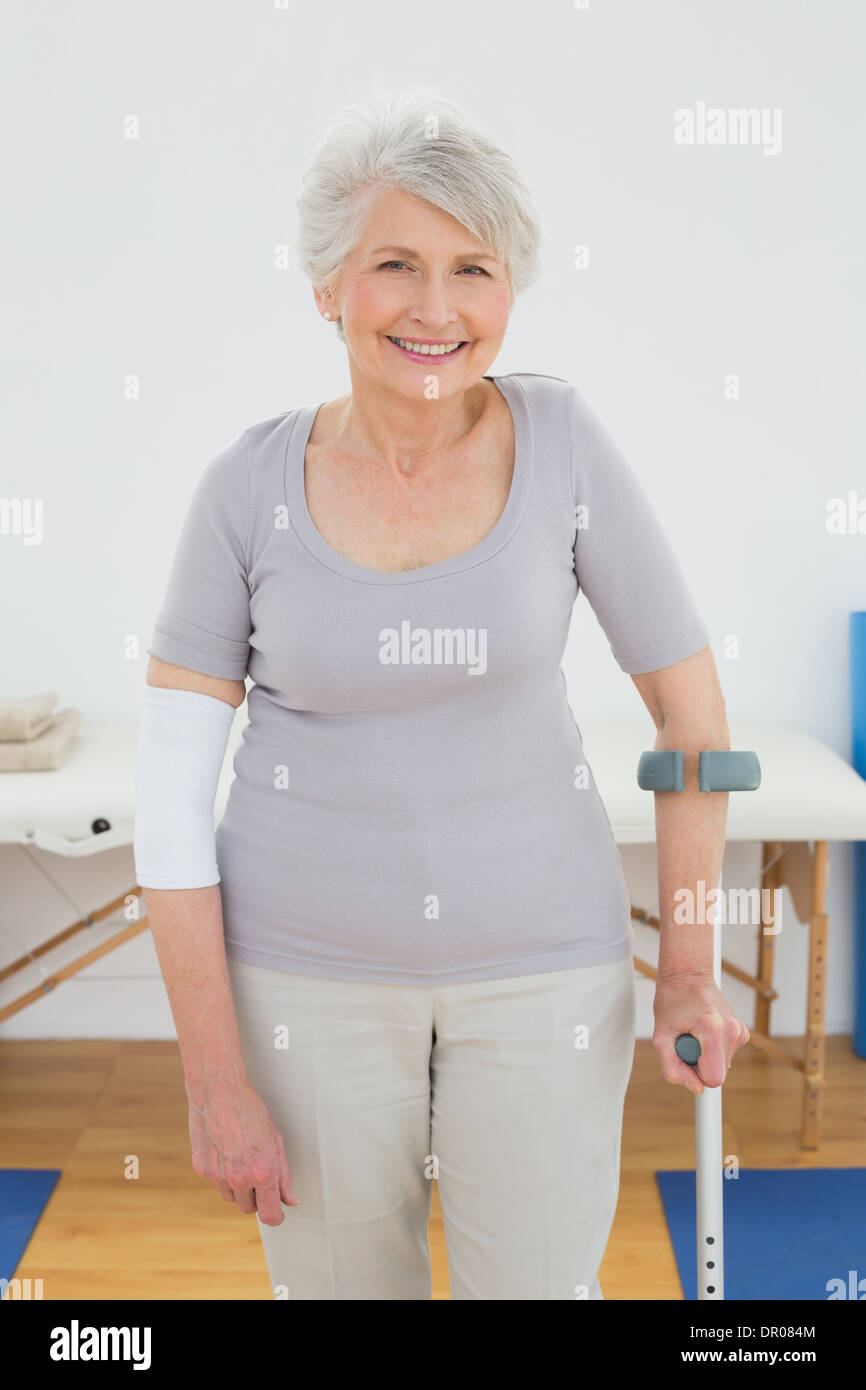 Porträt einer lächelnden senior Frau mit Krücke Stockfoto