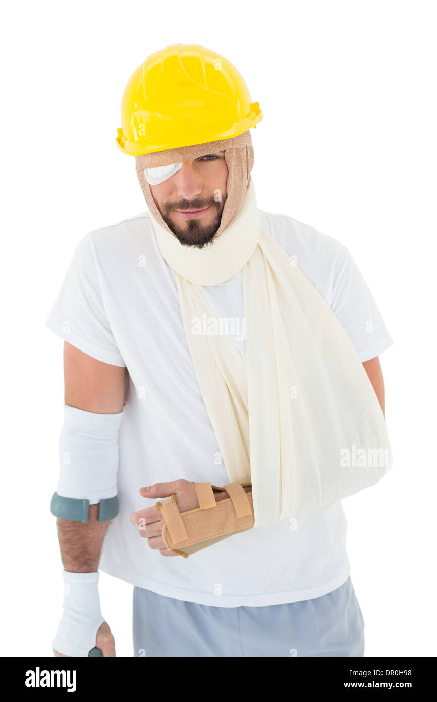 Mann im harten Hut mit gebrochenen Hand und Krücke Stockfoto