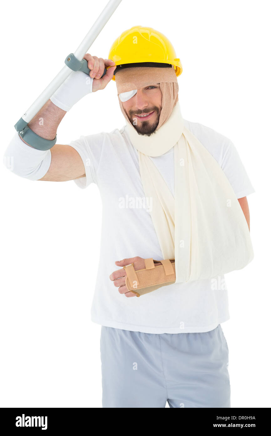 Porträt eines Mannes im harten Hut mit gebrochenen Hand und Krücke Stockfoto