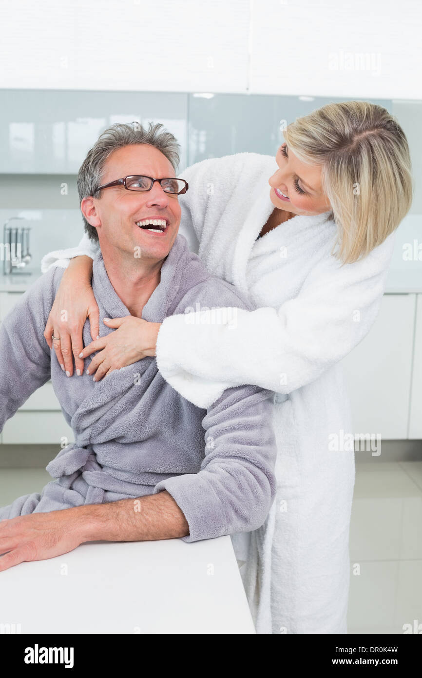 Frau, einen Mann von hinten umarmen, in Küche Stockfoto