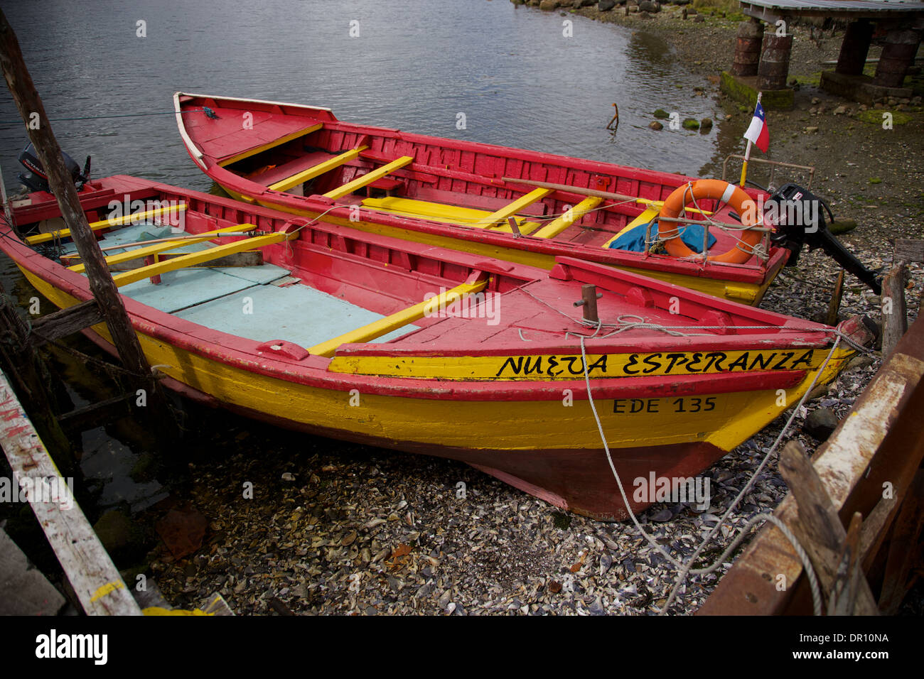 Rot und gelb Angelboote/Fischerboote am Strand in Puerto Eden Punta Arenas Patagonien Chile Südamerika gefesselt. Stockfoto