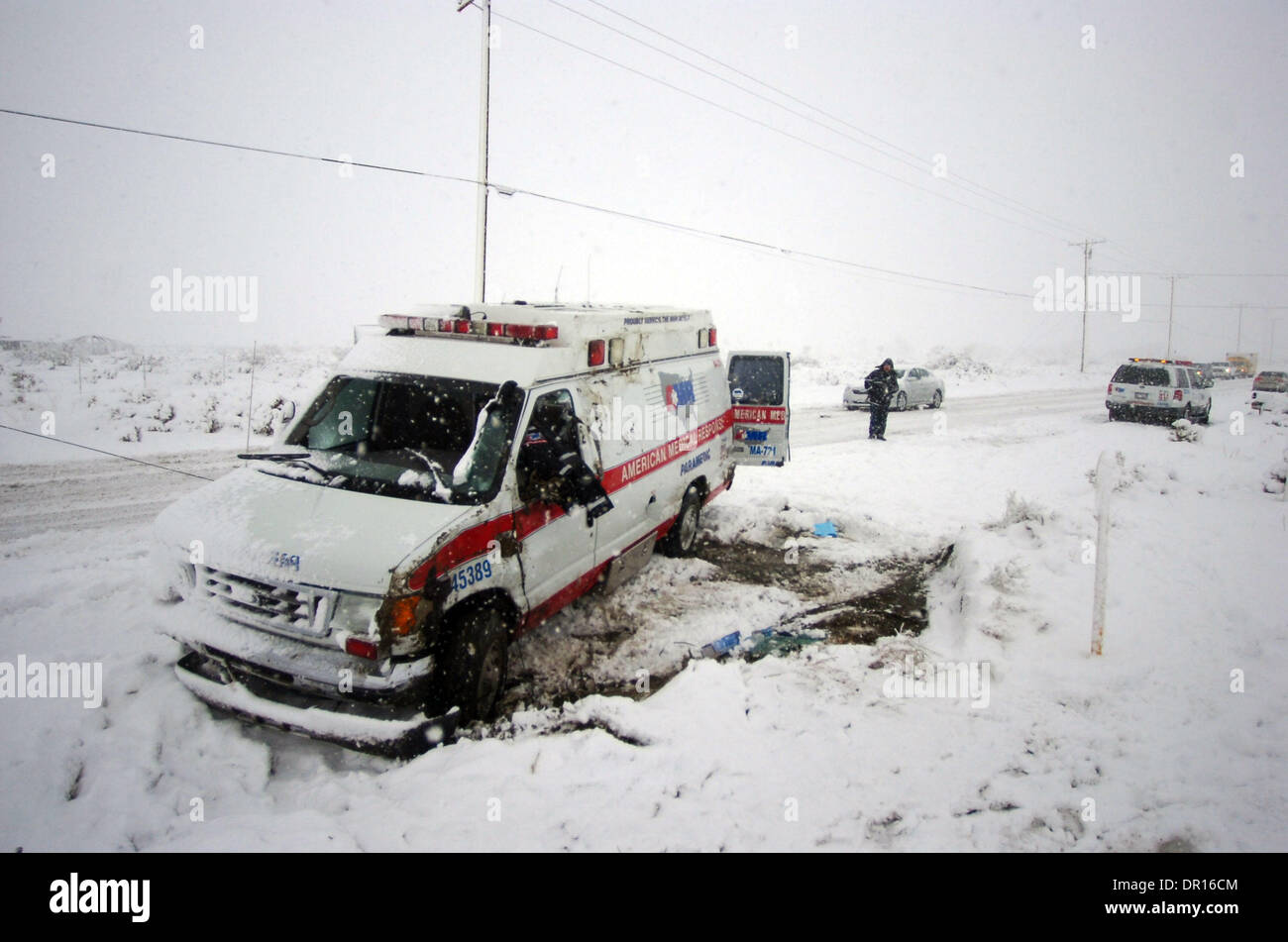 17. Dezember 2008 - Adelanto, Kalifornien, USA - ein AMR Supervisor nimmt Bilder als Fahrer eines Abschleppwagens arbeitet auf einen Krankenwagen, die im Schnee unterwegs El Mirage in der Nähe von Sheep Creek in El Mirage, Kalifornien rollte, wurde niemand verletzt, wie die High Desert täglich schweren Schnee auf Mittwoch, 17. Dezember 2008 erlebt. (Kredit-Bild: © Eric Reed/ZUMA Press) Stockfoto