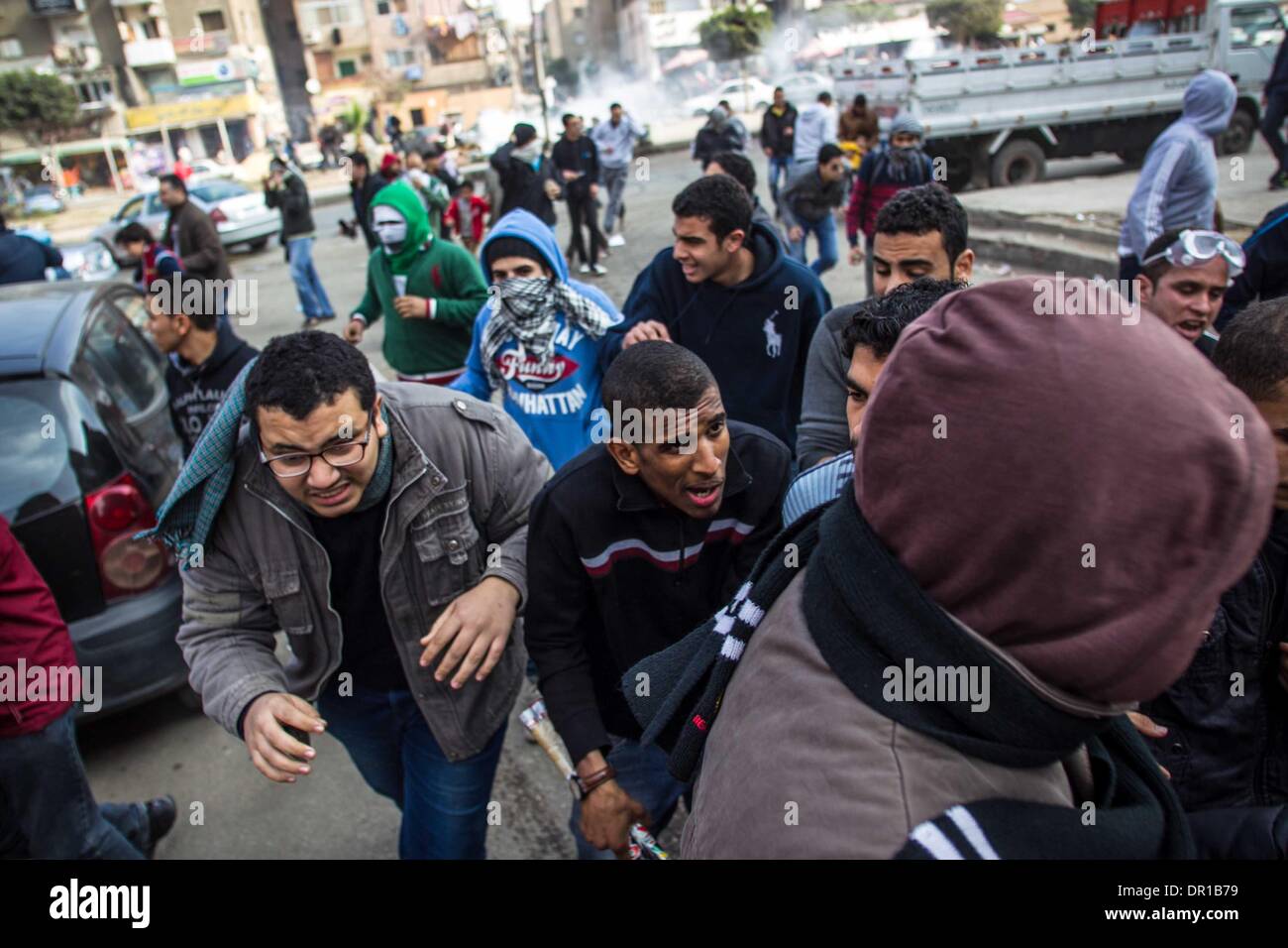 Kairo, Ägypten. 17. Januar 2014. Anti-Militär Demonstranten Tränengas abgefeuert von der Polizei in Kairo, Ägypten, 17. Januar 2014 zu entkommen. Mindestens einen Menschen starb am Freitag in Ägypten während der Auseinandersetzungen zwischen der Polizei und Anhängern des gestürzten islamistischen Präsidenten Mohamed Morsi, offizielle Website berichtete Al-Ahram-News. Bildnachweis: Amru Salahuddien/Xinhua/Alamy Live-Nachrichten Stockfoto