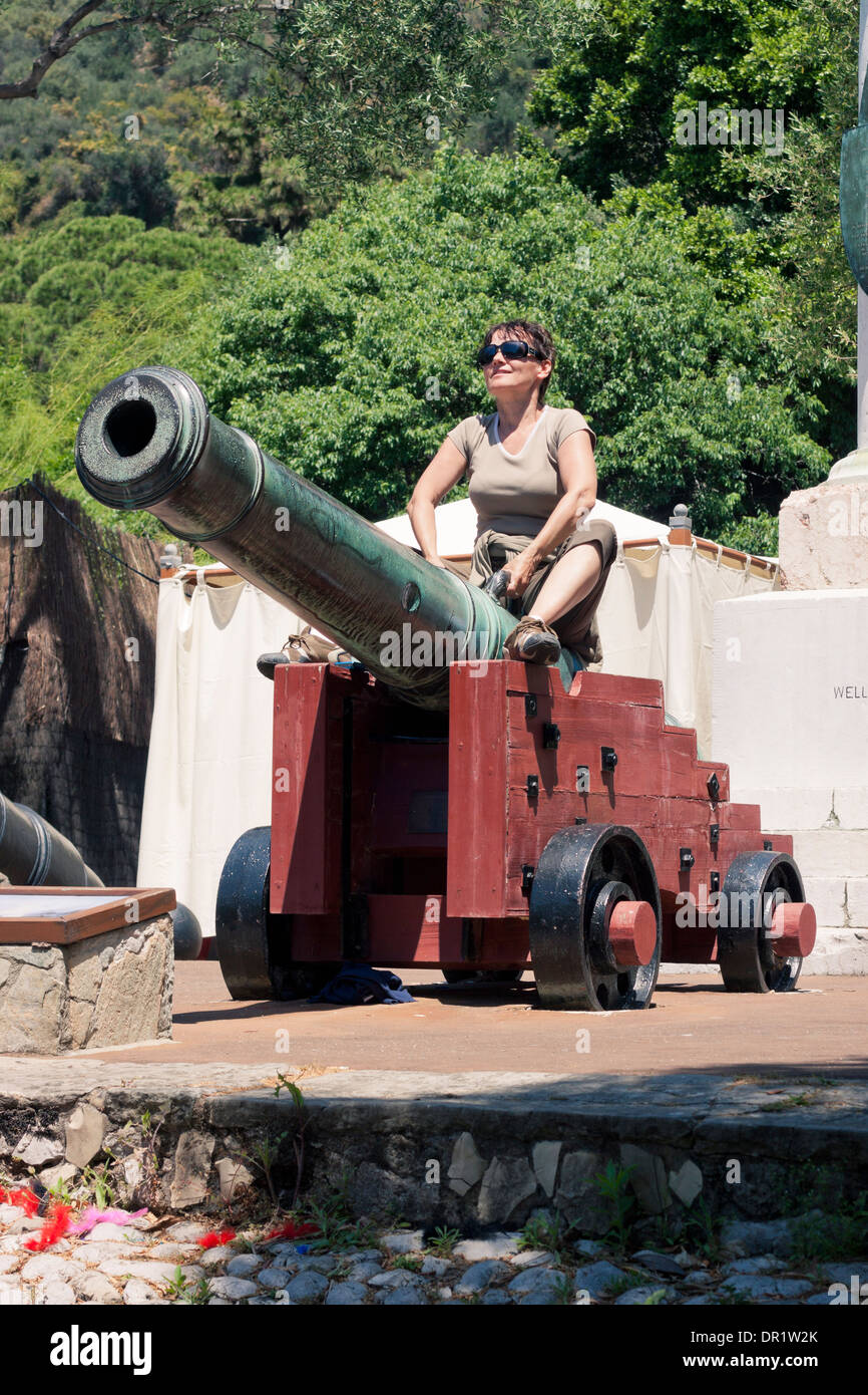 Happy Tourist Frau sitzen auf alte Kanone in Gibraltar. Stockfoto