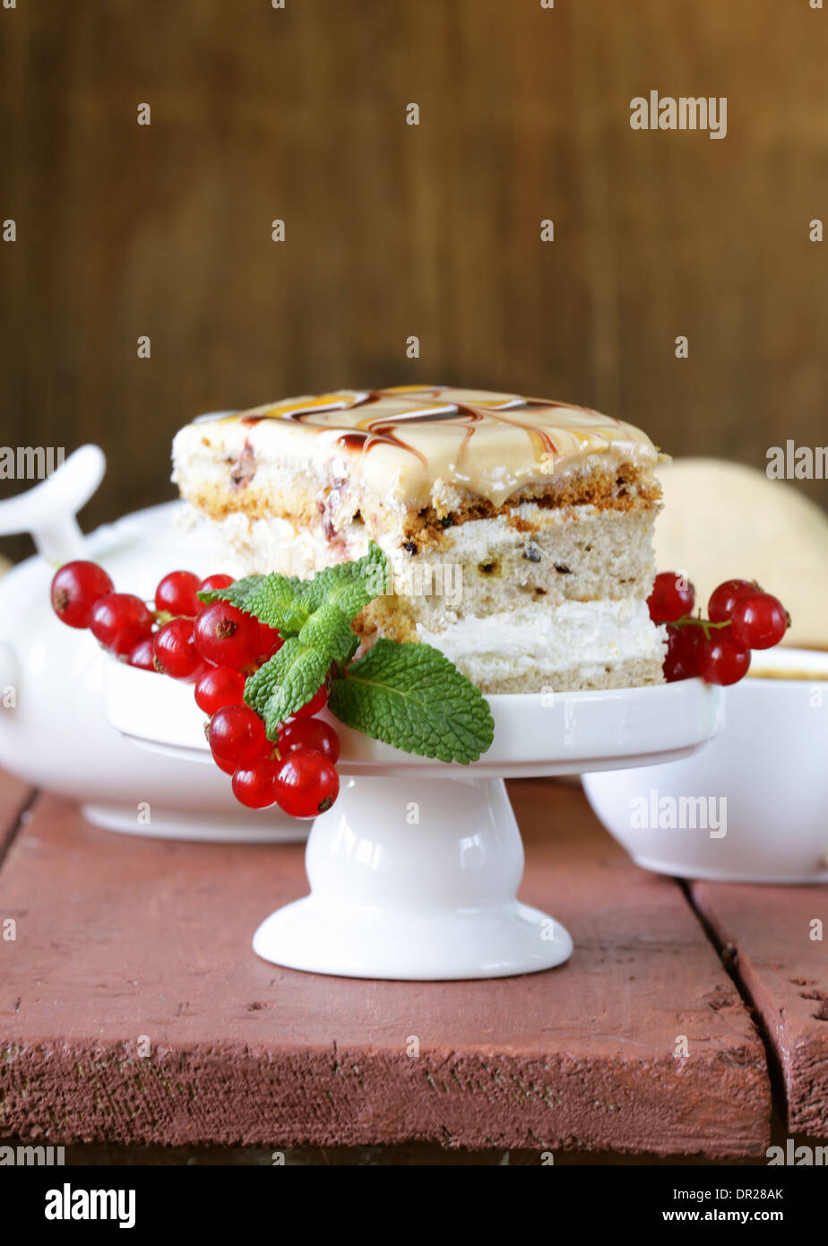 Stück Vanille Kuchen verziert, Karamellsauce und Johannisbeere Stockfoto