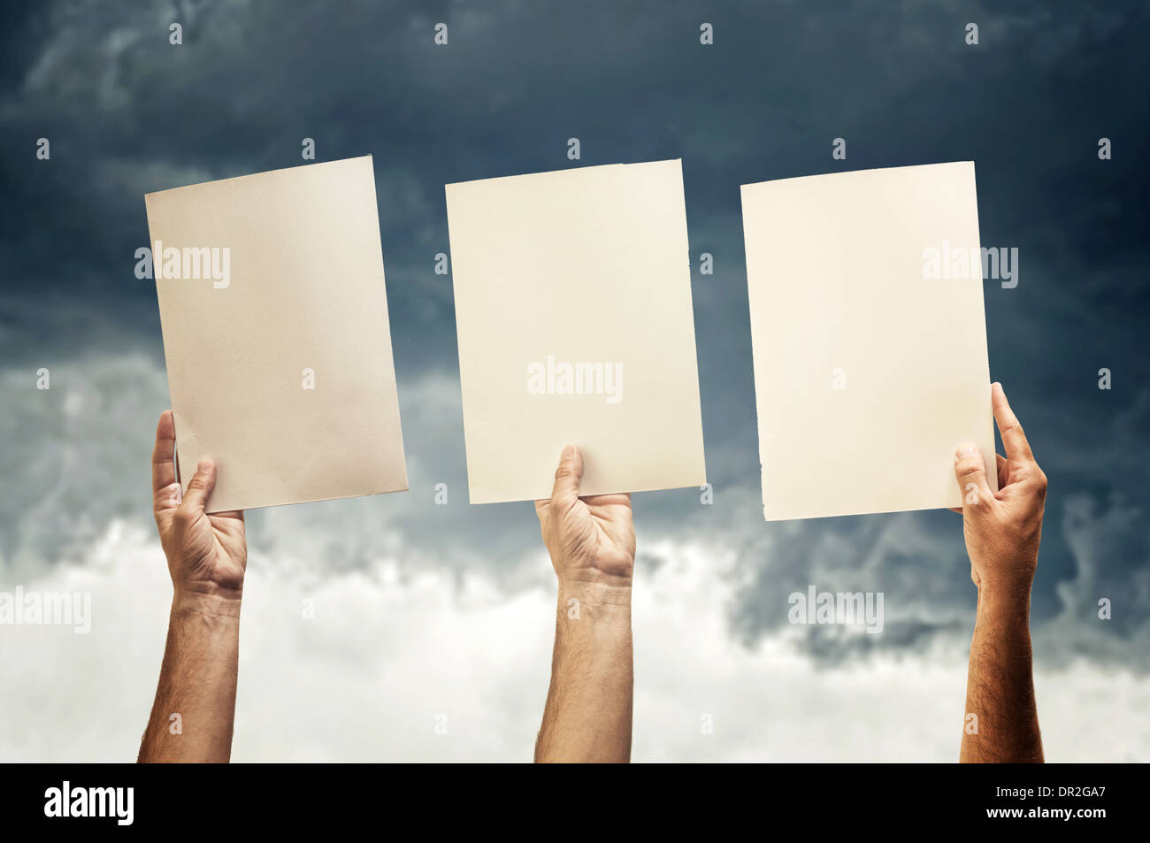 Menschliche Hände halten leere Papiere, stürmischen Himmel im Hintergrund. Stockfoto