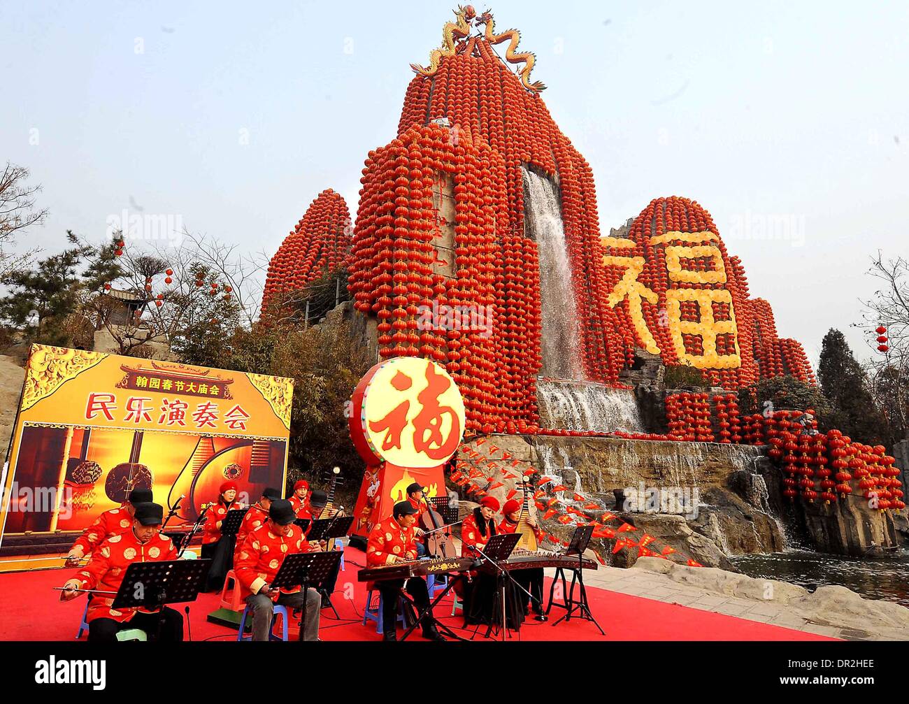 Zhengzhou. 18. Januar 2014. Foto aufgenommen am 8. Februar 2011 zeigt Darsteller spielen mit Musikinstrumenten vor einem Berg verziert durch das chinesische Schriftzeichen "Fu" während einer Tempel-Messe in Kaifeng, Henan Provinz Zentral-China. Das chinesische Schriftzeichen "Fu", was "Glück" bedeutet, ist überall in China während des Frühlingsfestes üblich. Es ist beliebt für seine günstigen Bedeutung, auch als "Glück", das die Chinesen glauben wird Ihnen Segen im kommenden neuen Jahr interpretiert werden können. © Wang Song/Xinhua/Alamy Live-Nachrichten Stockfoto