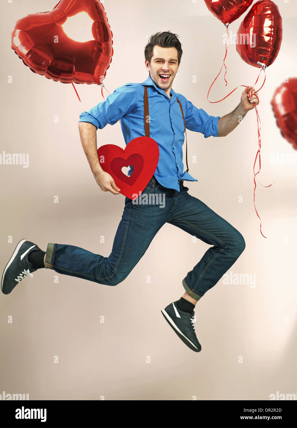 Lachen und springen Kerl mit Valentinstag Luftballons Stockfoto