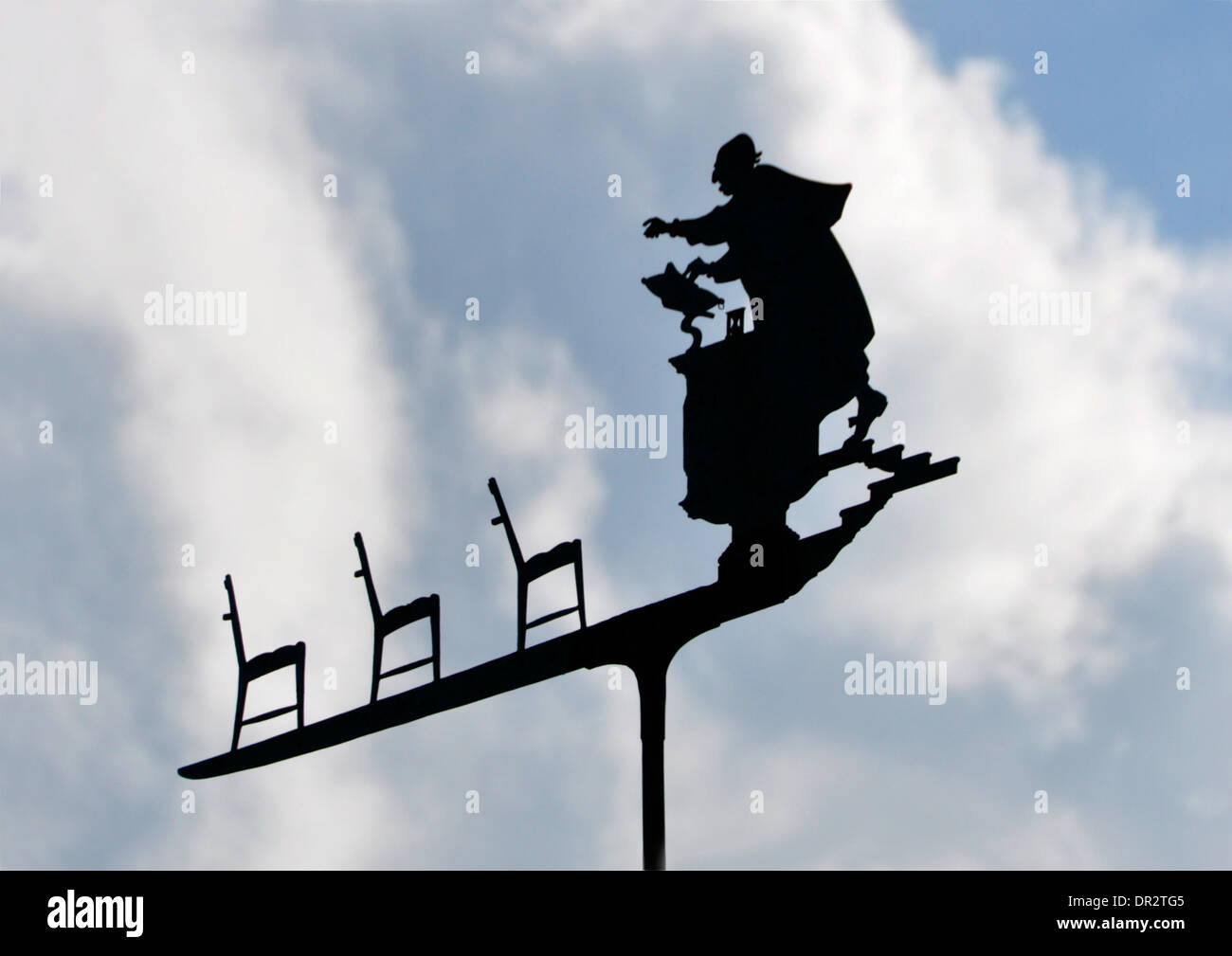 Ungewöhnliche Wetterfahne - Prediger im Gespräch mit leeren Kirchenbänken - Silhouette gegen den Himmel - weiße Wolken und blauer Himmel - Sonnenlicht Stockfoto