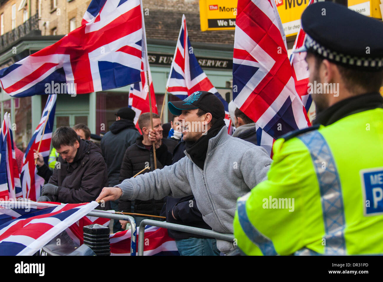 London, UK. 18. Januar 2014.  Ein Polizist beobachtet, wie "Patriot"-Gruppe, die in Cricklewood, North London gegen die Gründung eines Büros von verbotenen Muslimbruderschaft Ägyptens Britain First zeigt. Bildnachweis: Paul Davey/Alamy Live-Nachrichten Stockfoto