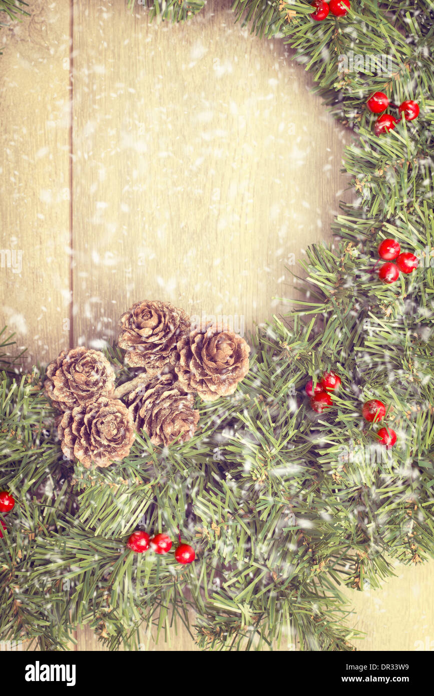 Weihnachtsgirlande von Holztür mit fallendem Schnee hängen Stockfoto