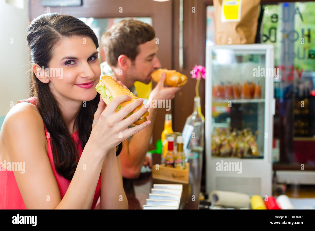 Hotdog - junge Kunden in einer Snackbar essen leckere Fastfood Würstchen Stockfoto