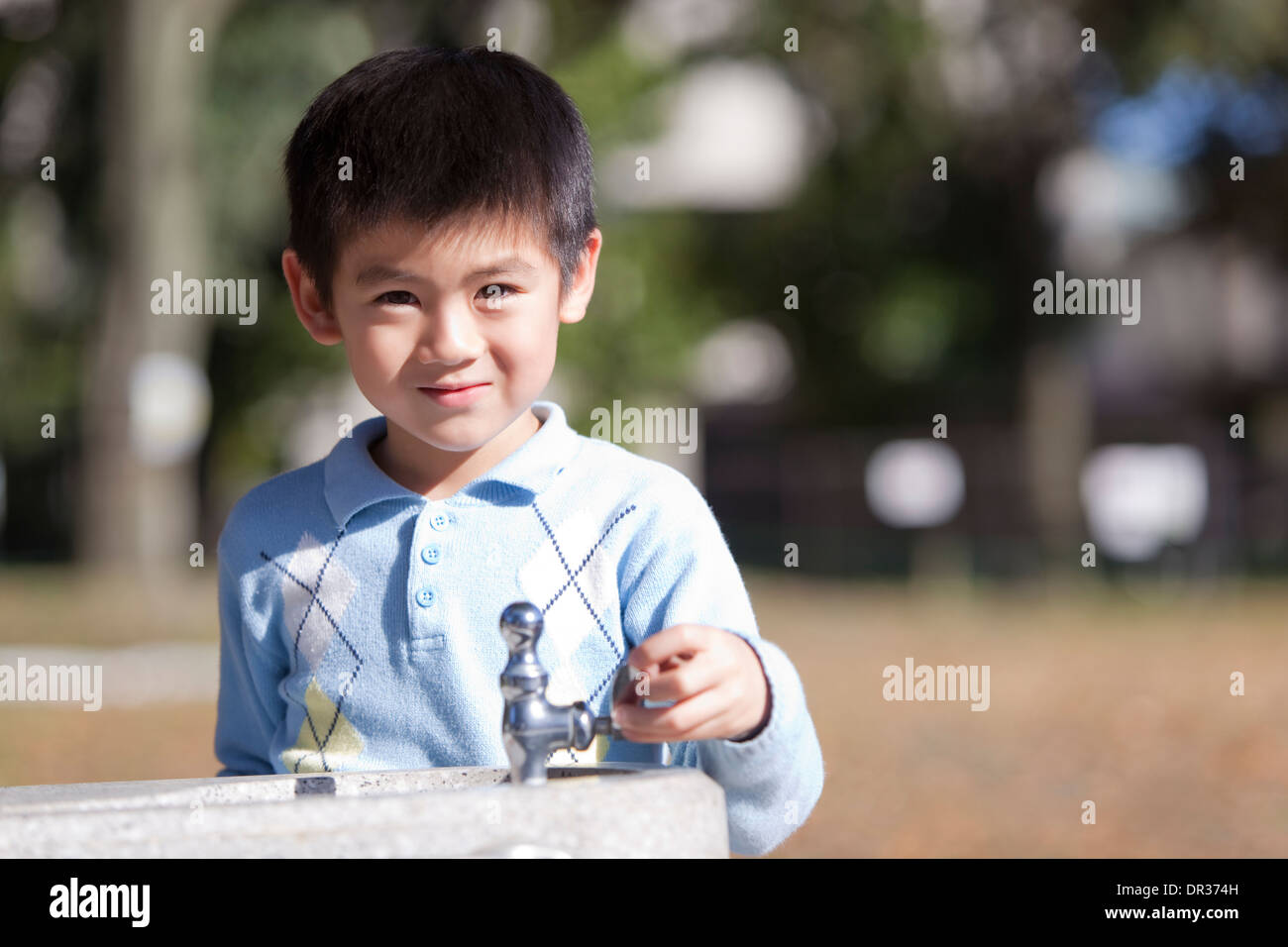 Junge am Brunnen Stockfoto
